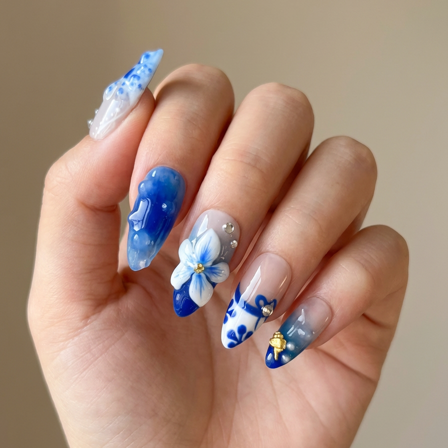 Hand with blue and white floral nail art on a neutral background