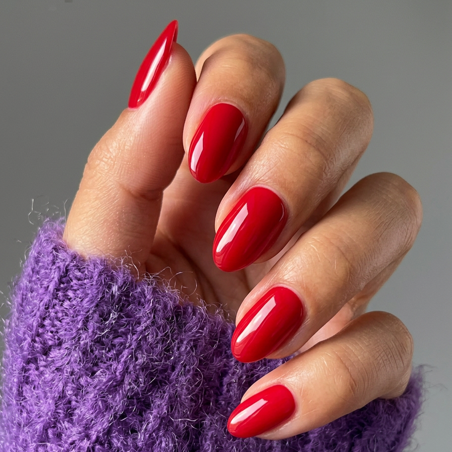 Hand with red nail polish wearing a purple textured sleeve against a gray background