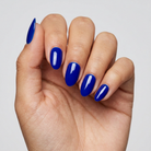 Hand with blue nail polish on a plain background